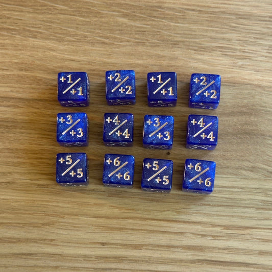 Set of twelve 12mm D6 +/+ plus plus dice in glitter blue with gold infil. each dice is numbered 1-6 on each side to track incremental positive modifiers.