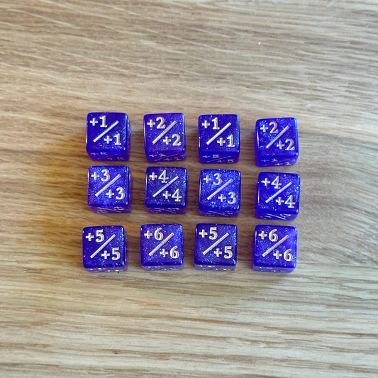 Set of twelve 12mm D6 +/+ plus plus dice in glitter purple with gold infil. each dice is numbered 1-6 on each side to track incremental positive modifiers.