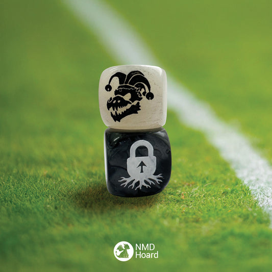 Stacked 16mm acrylic D6. Top dice is white featuring a dinosaur bone skull with a three pointed jester hat representing 'bone head' in black infill and 5 blank sides. Bottom dice is black featuring a padlock growing roots with an arrow as the key lock representing 'rooted' in white infill and 5 blank sides.