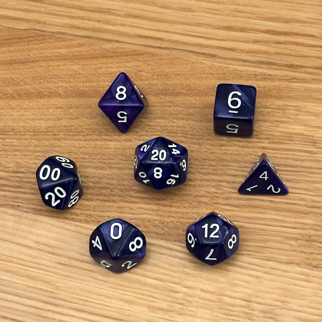 Set of 7 polyhedral dice (D4, D6, D8, D10, percentile D10, D12, D20) in swirled purple acrylic with white number infill.