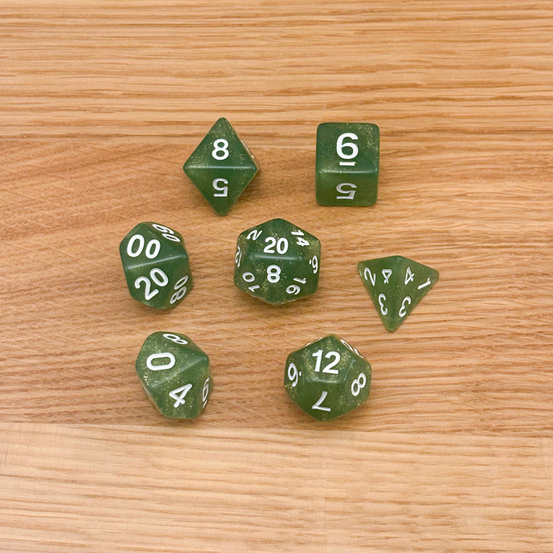 Set of 7 polyhedral dice (D4, D6, D8, D10, percentile D10, D12, D20) in green glitter acrylic with white number infill.