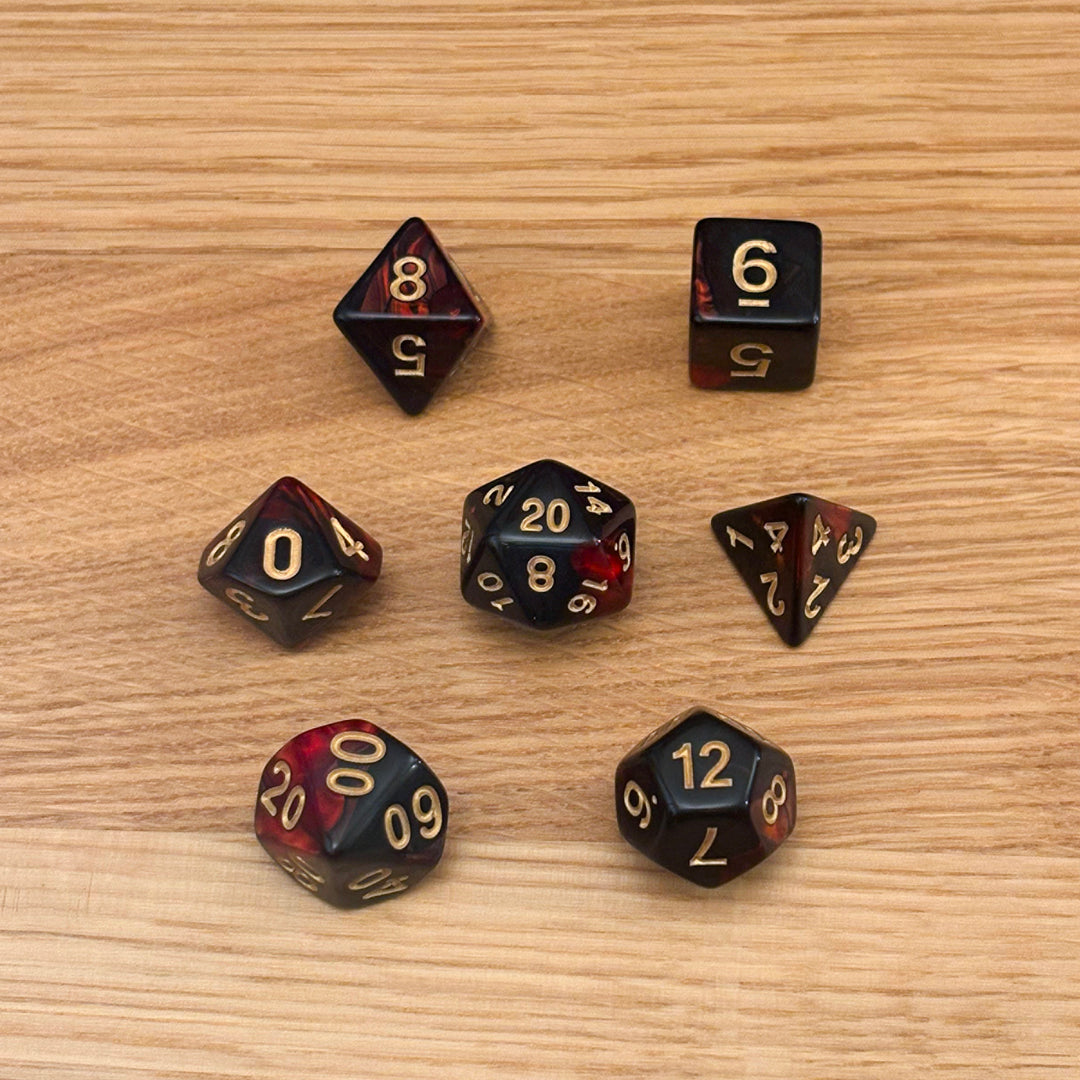 Set of 7 polyhedral dice (D4, D6, D8, D10, percentile D10, D12, D20) in swirled red and black acrylic with white number infill.