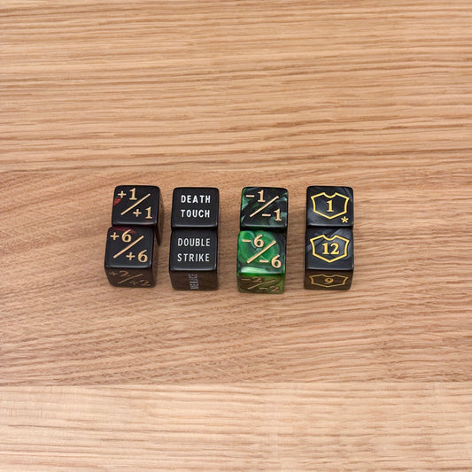 Set of six counter dice, including red +1/+1 counters, black text dice with keywords like 'Death Touch' and 'Double Strike', green -1/-1 counters, and black loyalty counters with yellow shield icons.